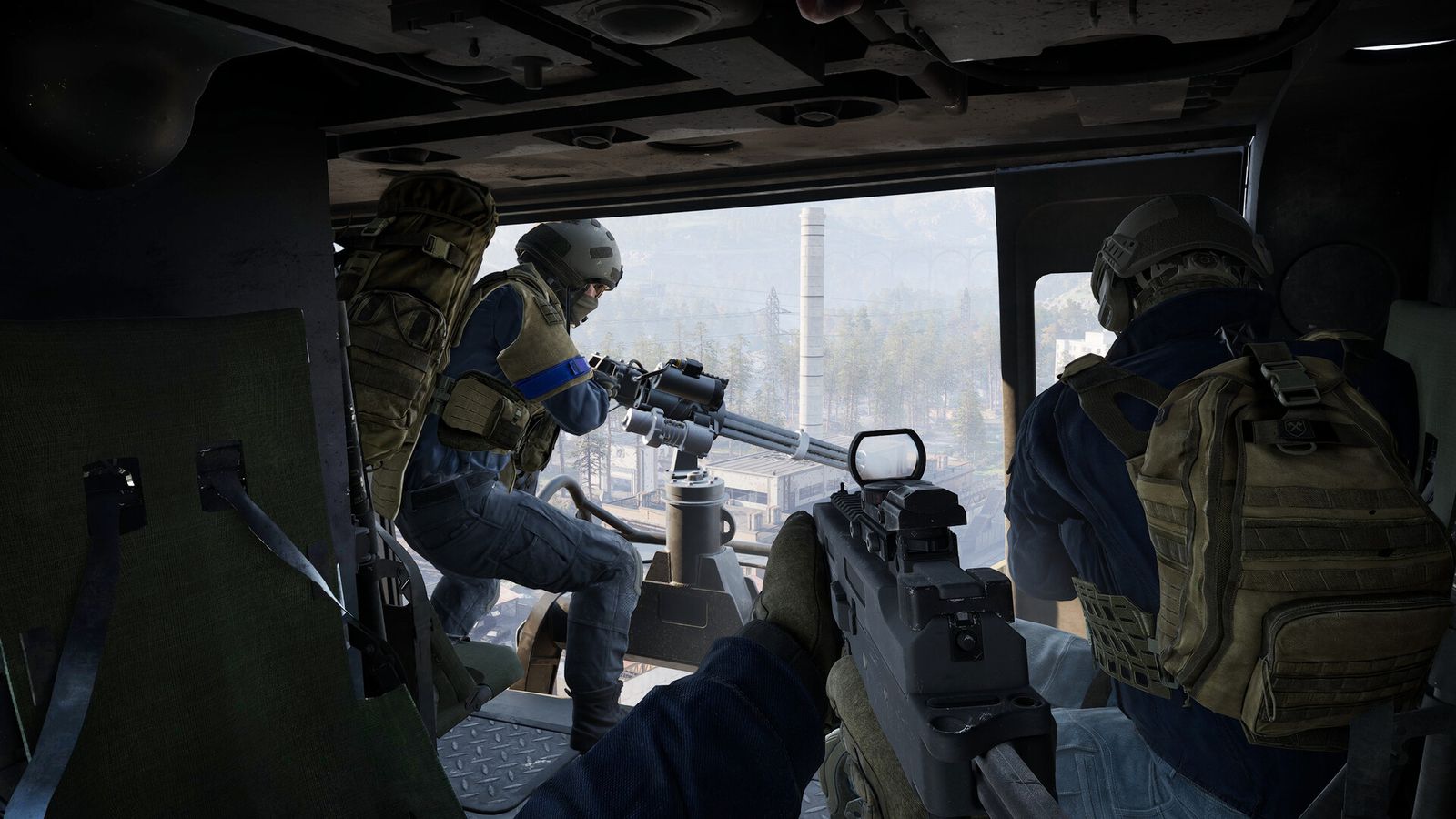 A WARDOGS door gunner firing from the open side of a helicopter over farmland